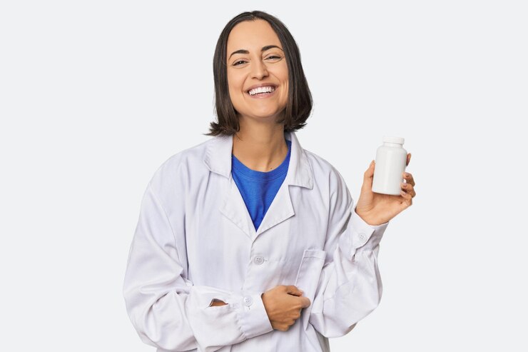 Foto jovem farmacêutica caucasiana com comprimidos a rir e a divertir-se.