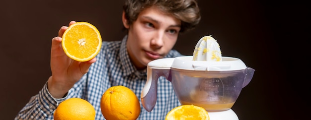 Jovem faz suco com laranja fresca b