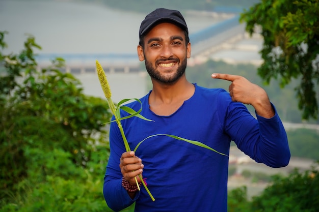 Jovem fazendeiro bonito com planta