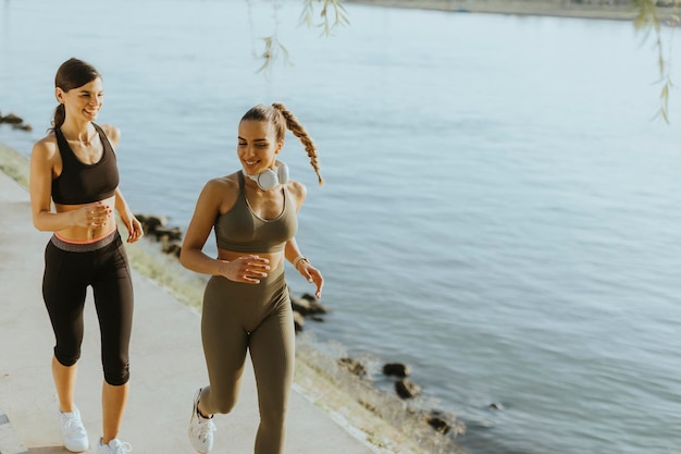 Jovem fazendo exercício de corrida à beira do rio