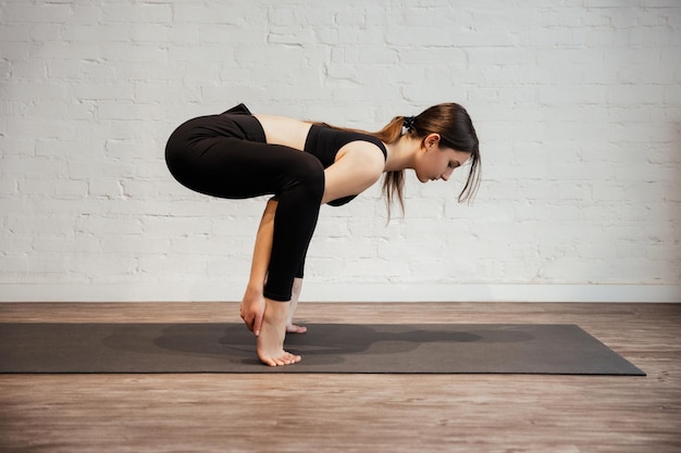 Jovem fazendo exercício esportivo Crane ou Crow Pose Bakasana