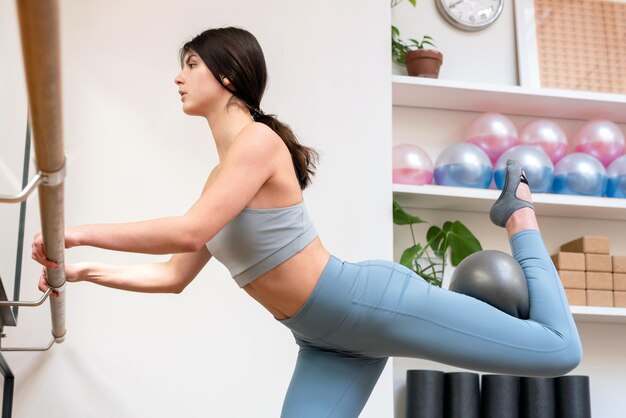 Jovem fazendo exercícios de barra com fit ball