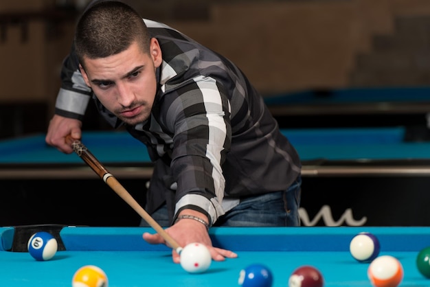 Jovem fazendo forro para bater bola na mesa de bilhar