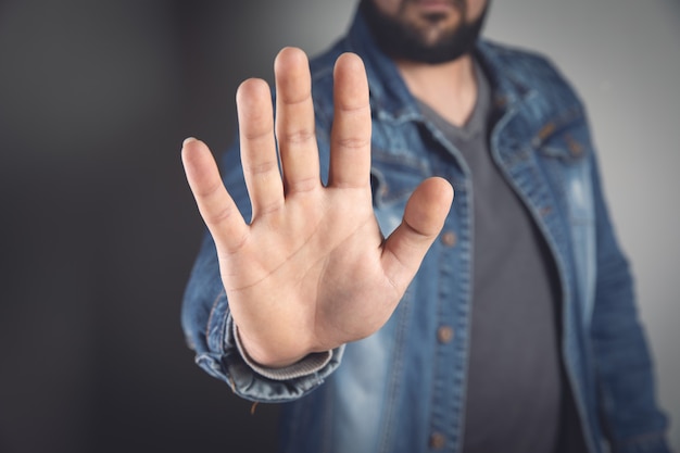 Jovem fazendo um sinal de pare com as mãos