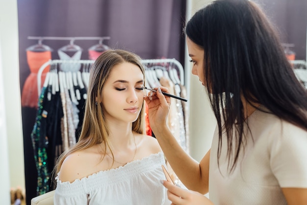 Jovem fazendo uma maquiagem natural para uma modelo