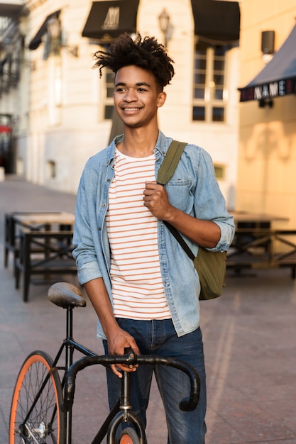 Jovem feliz andando de bicicleta ao ar livre na rua