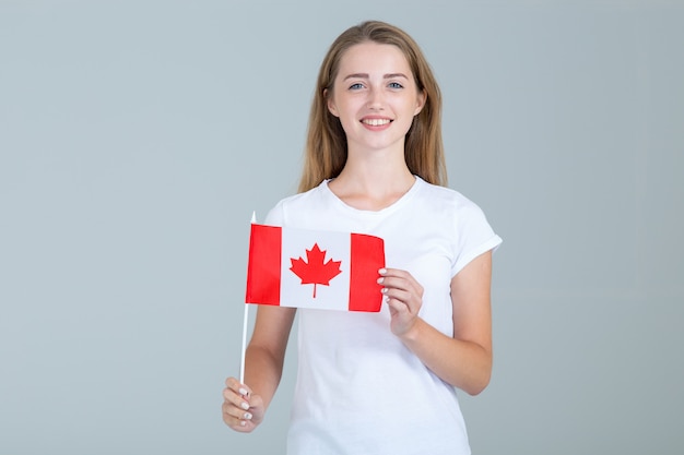 Foto jovem feliz com a bandeira do canadá em cinza