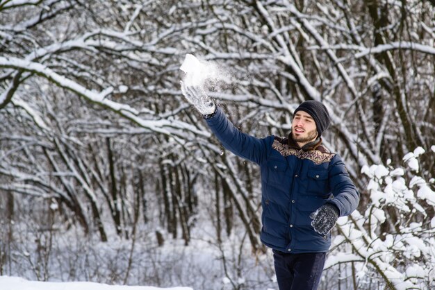 Jovem feliz com barba jogar bola de neve