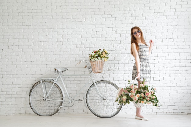 Jovem feliz com bicicleta vintage e flores