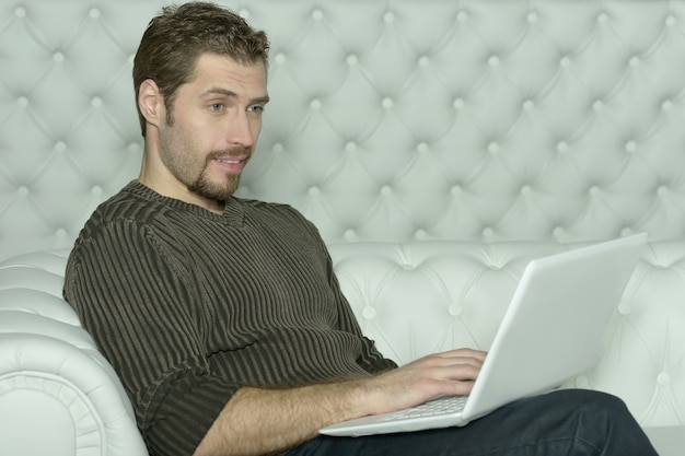 Jovem feliz com computador laptop em casa