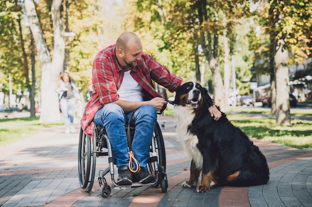 Jovem feliz com deficiência física em uma cadeira de rodas com seu cachorro