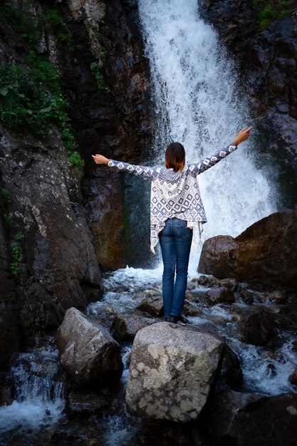 Jovem feliz desfrutando da cachoeira de verão