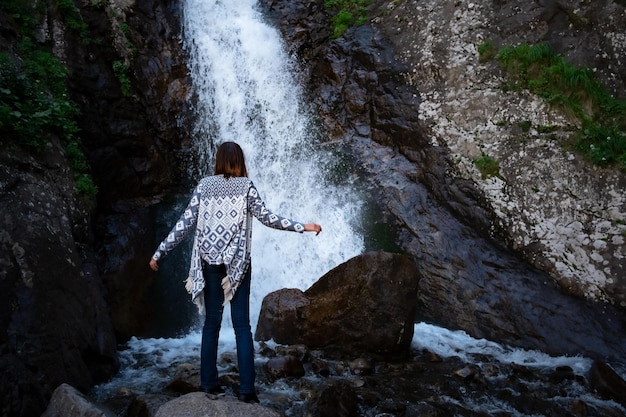 Jovem feliz desfrutando da cachoeira de verão