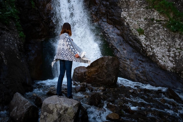 Jovem feliz desfrutando da cachoeira de verão