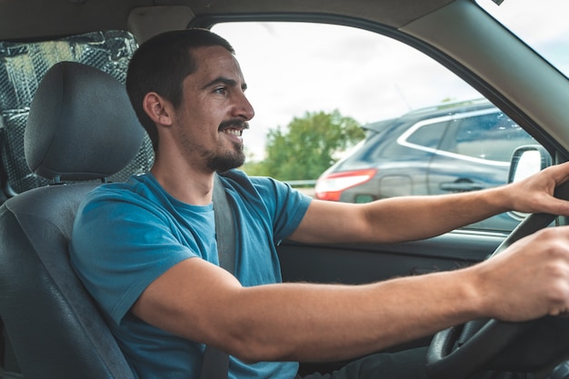 Jovem feliz dirigindo um carro, dançando e cantando. Viagem divertida, transporte e conceito de veículo