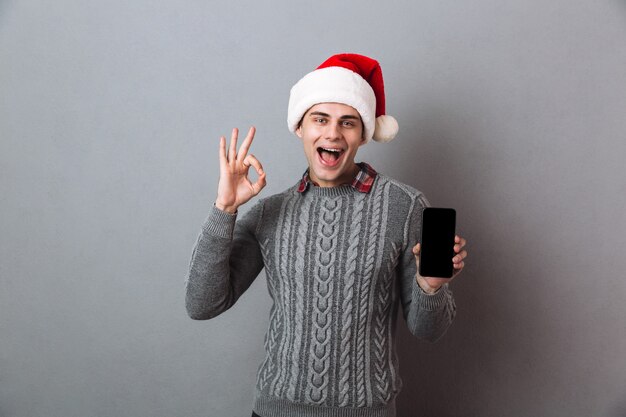 Jovem feliz e emocional com chapéu de Papai Noel