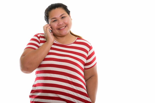 jovem feliz e gorda asiática sorrindo enquanto fala ao telefone