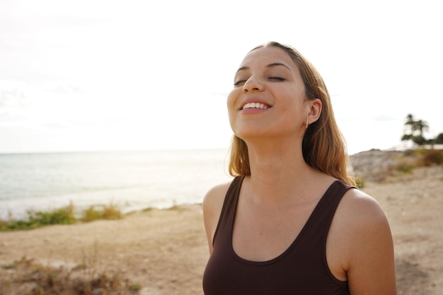 Jovem feliz e relaxada respirando ar fresco na praia