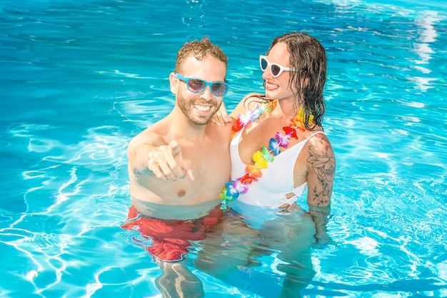 Jovem feliz e sexy casal apaixonado na piscina do resort