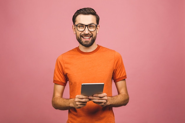 Jovem feliz em pé casual e usando tablet