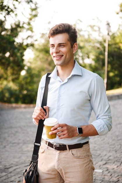 Jovem feliz em uma camisa carregando uma sacola andando