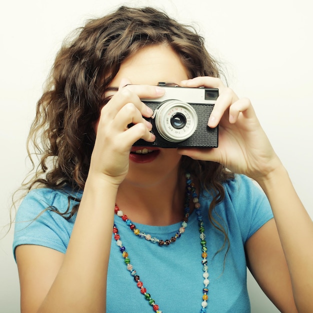 Foto jovem feliz encaracolada com câmera vintage