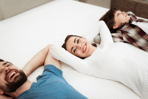 Jovem feliz família deitado no colchão na loja