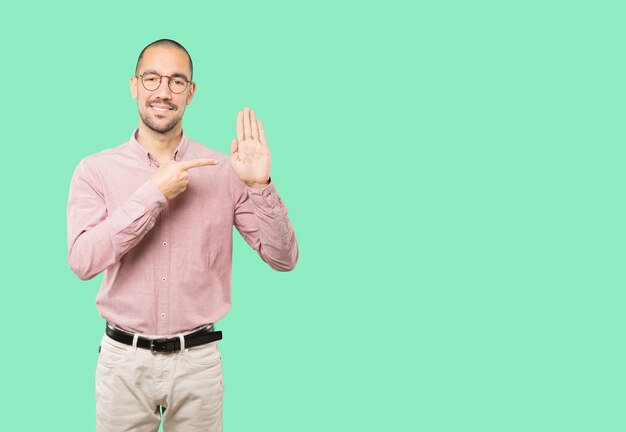 Jovem feliz fazendo um gesto de parada com a palma da mão