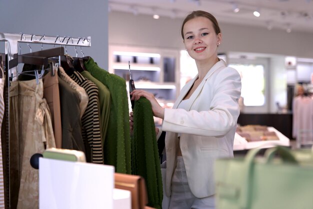 Foto jovem feliz mulher bonita garota elegante está fazendo compras no centro comercial ao ar livre segurando sacos na mão