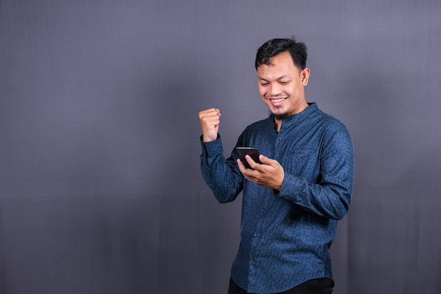 Jovem feliz na camisa azul posando isolado no retrato de estúdio de fundo cinza. conceito de estilo de vida