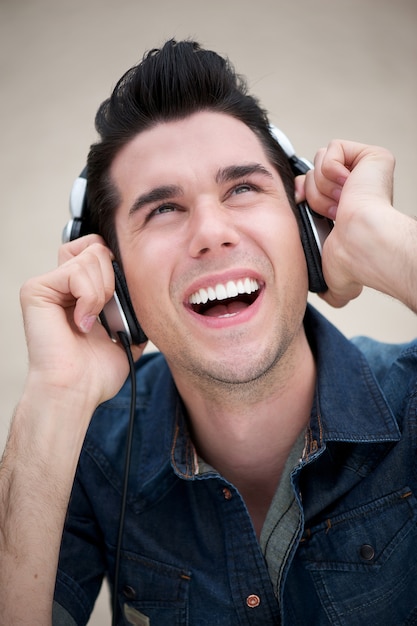 Jovem feliz ouvindo música em fones de ouvido ao ar livre