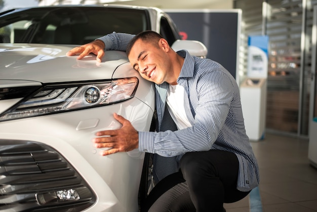 Jovem feliz por seu carro novo