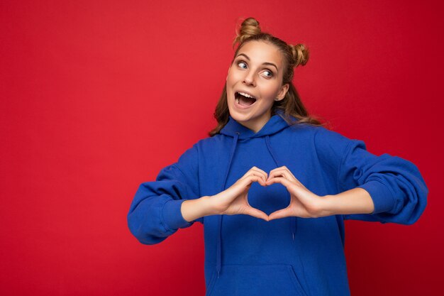 Jovem feliz positiva loira atraente com dois chifres e emoções sinceras vestindo roupas elegantes