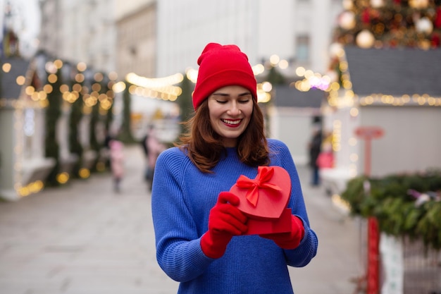 Jovem feliz recebendo um presente em uma caixa na feira de Natal