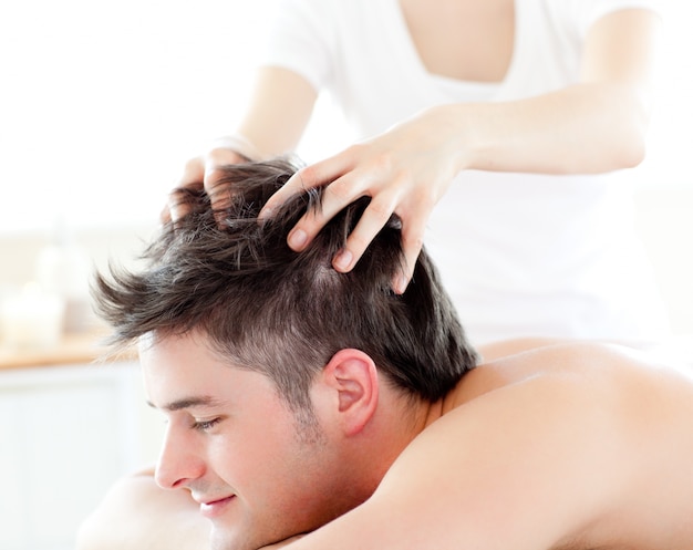 Jovem feliz recebendo uma massagem na cabeça