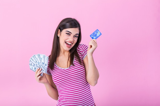 jovem feliz segurando dinheiro e cartão de crédito.