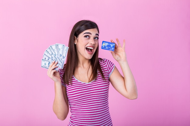 jovem feliz segurando dinheiro e cartão de crédito.