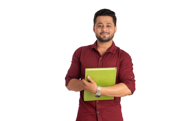 Jovem feliz segurando e posando com o livro em fundo branco