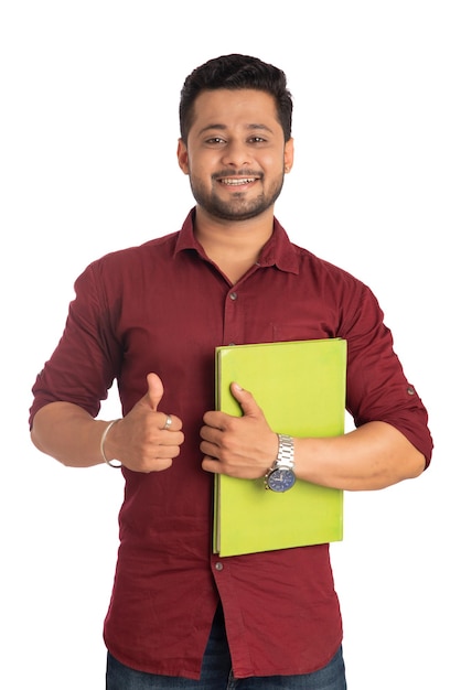 Jovem feliz segurando e posando com o livro em fundo branco