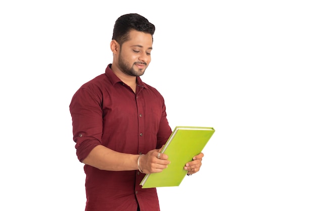 Jovem feliz segurando e posando com o livro em fundo branco