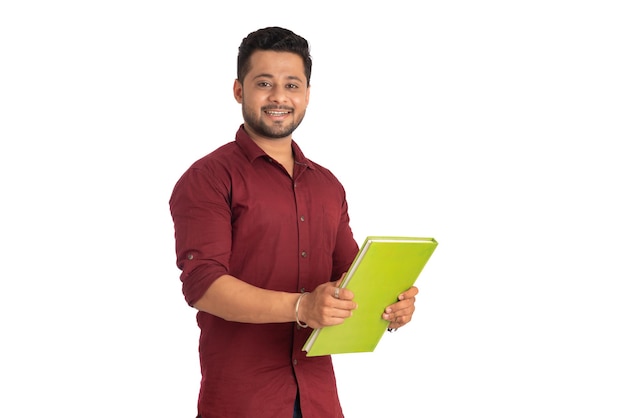 Jovem feliz segurando e posando com o livro em fundo branco