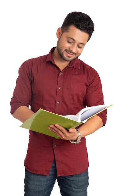 Jovem feliz segurando e posando com o livro em fundo branco