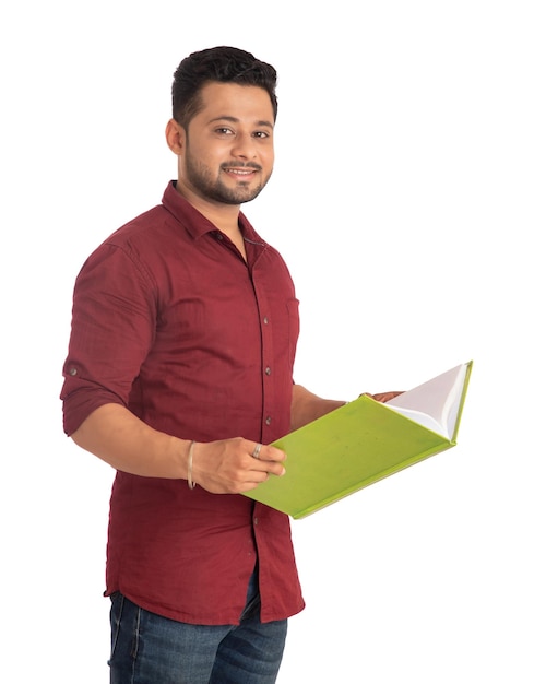 Jovem feliz segurando e posando com o livro em fundo branco