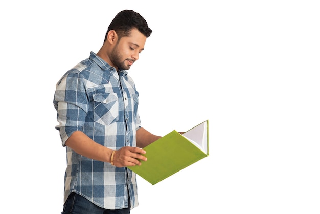 Foto jovem feliz segurando e posando com o livro em fundo branco