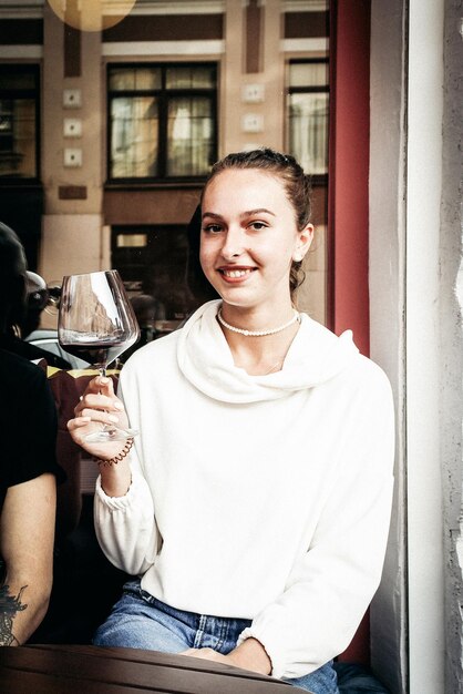 Foto jovem feliz segurando um copo de vinho