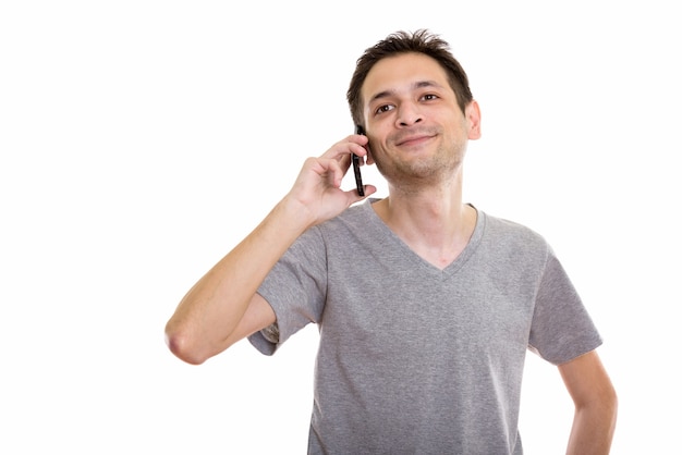 jovem feliz sorrindo e pensando enquanto fala ao telefone