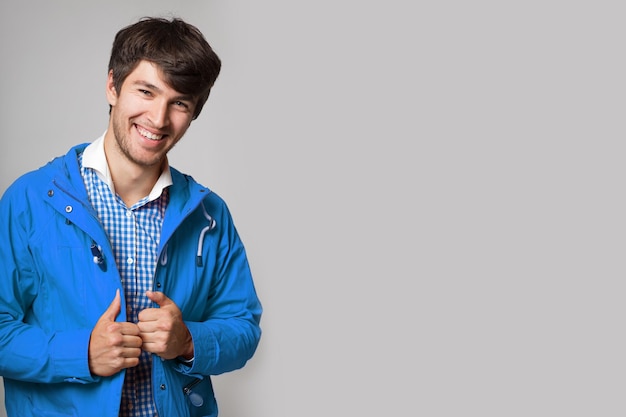 Jovem feliz sorrindo em uma camisa xadrez azul e uma jaqueta azul