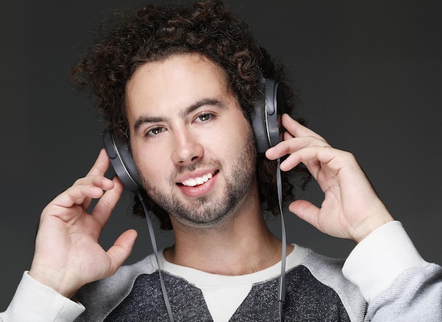 Jovem feliz sorrindo ouvindo música em fones de ouvido
