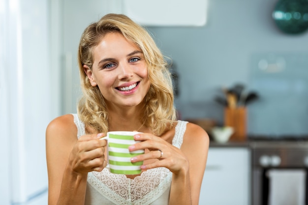 Jovem feliz tomando café em casa