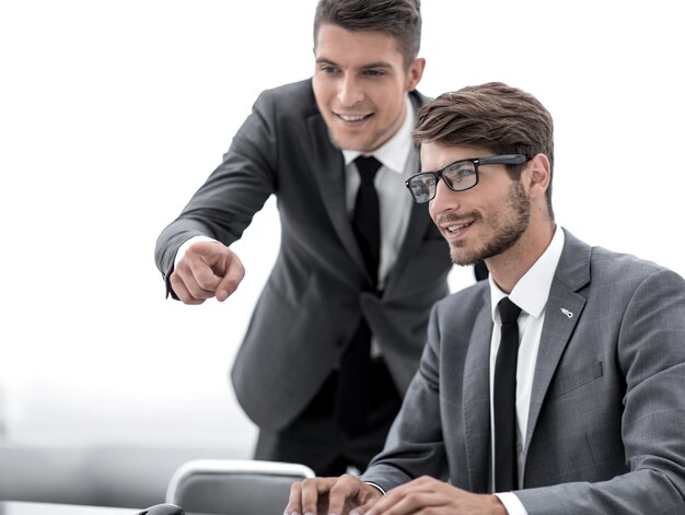 Jovem feliz usando óculos e sorrindo enquanto trabalha em seu laptop para fazer todos os seus negócios no início da manhã